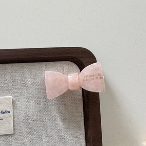 Détail de la pince à cheveux nœud rose en acétate avec gravure dorée France Handmade dessus