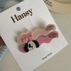 Close-up of pink wave hair clips with bow and cartoon dog on white display card