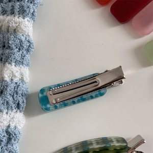 Detail of blue and white checkered acetate hair clip with silver metal duckbill base