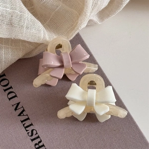 Gros plan sur des pinces à cheveux nśud en résine de couleur lilas et blanc