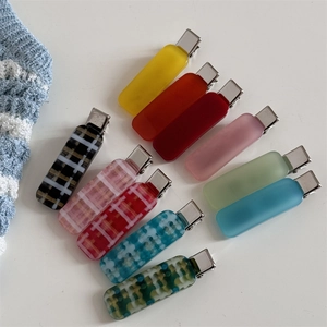 Flat lay of 10 rectangular hair clips with matte solid colors and checkered patterns