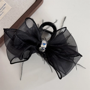 Detail of black bow hair claw clip with delicate mesh feathers and sparkling crystals