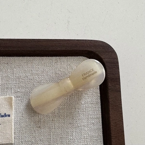 Détail du clip de cheveux en acétate crème montrant la gravure France Handmade