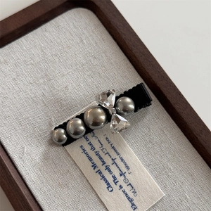 Detailed shot of bow-shaped crystal and grey pearls on an elegant vintage hair clip