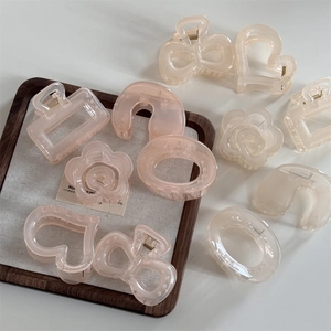 Translucent camellia hair claws in heart and flower shapes with elegant glossy finish