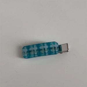Detail of blue and white acetate checkered hair clip with silver metal duckbill base