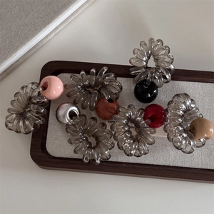 Élastiques à cheveux spirale avec perles colorées présentés sur plateau en bois