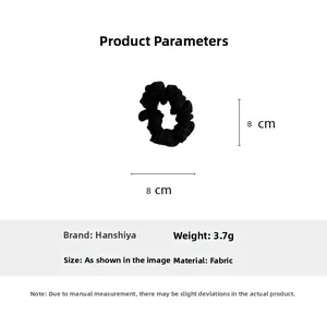 Detail showing an 8cm black fabric hair scrunchie with soft pleated texture and 3.7g weight