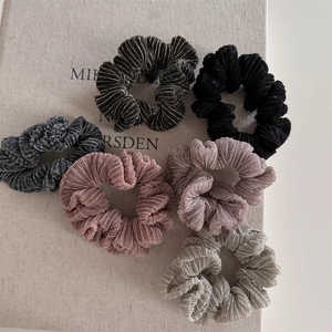 Detailed view of shimmering pleated scrunchies in diverse metallic fabric colors