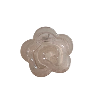 Translucent camellia flower hair claw clip in champagne resin with a strong metal spring