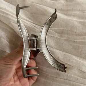 Detailed macro shot of large silver metal hair claw showing its X-shaped structure