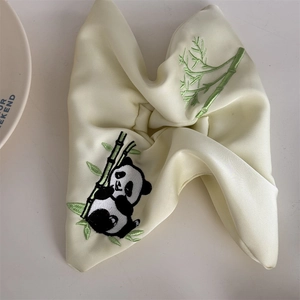 Nahaufnahme von cremefarbenem Satin-Haargummi mit Panda- und Bambus-Stickerei