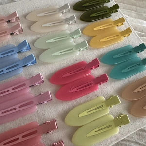 Flat lay of colorful matte duckbill hair clips in vibrant jelly candy colors on fabric