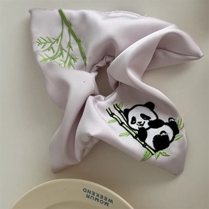 Detail der Panda-Stickerei auf einem zartrosa Satin-Haargummi mit China-Motiv
