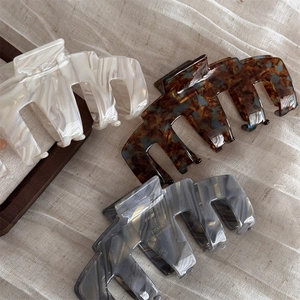 Retro acetate hair claw clips in pearl white, tortoiseshell, and marble grey colors