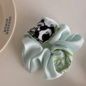 Detail eines Satin-Haargummis mit Panda-Stickerei und Bambusmuster in Hellblau