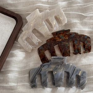 Detailed set of three acetate hair claws in beige, tortoiseshell, and marble patterns