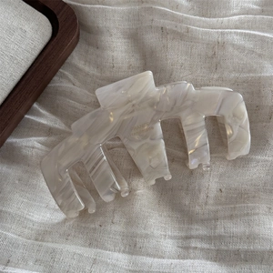 Detailed macro view of acetate hair claw showing marble texture and France Handmade logo