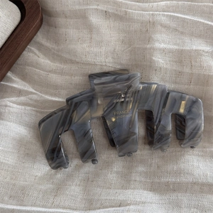 Detail of grey marble acetate claw clip with gold France Handmade logo on fabric