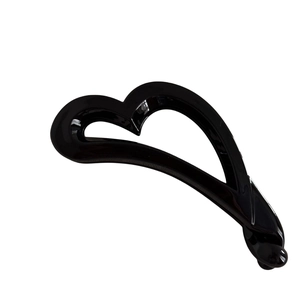 Pince banane en forme de cœur noir brillant avec design évidé sur fond blanc épuré