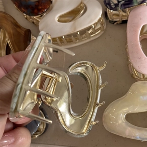 Detail showing the internal metal spring and marble texture of the French hair claw clips