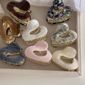 Assorted heart-shaped acetate hair claws in tortoise shell and marble patterns