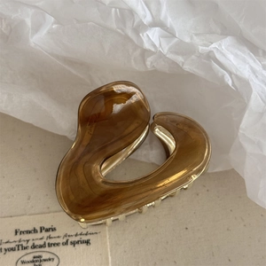 Close-up of tortoise shell resin hair claw with golden metal base in French retro style