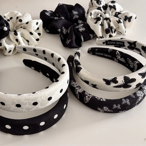 Detailed view of handmade black and white polka dot headband and matching scrunchie set