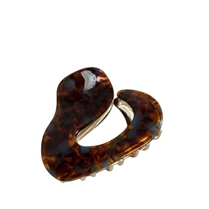 Elegant french tortoise shell acetate hair claw clip with dark pattern on white background
