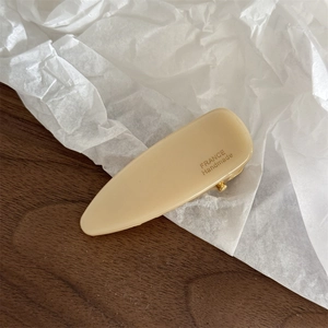 Detailed macro view of a cream acetate hair clip featuring gold FRANCE Handmade lettering
