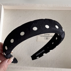 Detailed macro view of black polka dot headband featuring handmade textured floral jacquard