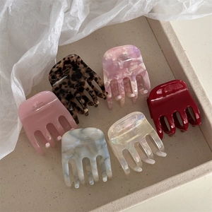 Lot de 6 pinces à cheveux élégantes en acétate coloré sur un plateau d'exposition