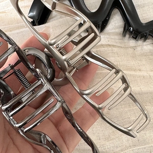 Dettagli di grandi mollettoni per capelli in metallo ondulato argento e canna di fucile