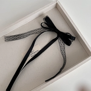 Vue détaillée du nœud en satin noir avec ruban de dentelle à pois élégant pour cheveux