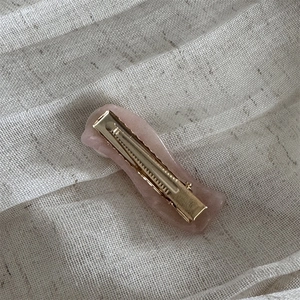 Detail von rosa marmorierter Acetat-Haarklammer mit goldenem Metallverschluss
