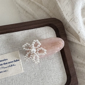Nahaufnahme der rosa Acetat-Haarklammer mit Perlenblume und handgefertigtem Schriftzug