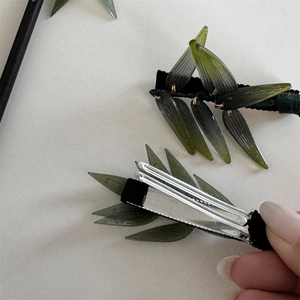 Détail de la pince à cheveux feuille de bambou avec feuilles en résine et clip bec de canard