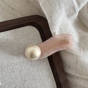 Detail der Haarspange aus rosa Acetat mit Perle und handgefertigter Gravur aus Frankreich