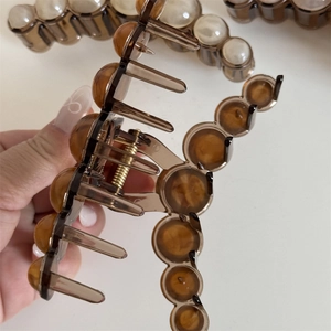 Detail showing the inner gold spring mechanism of the large amber resin hair claw clip