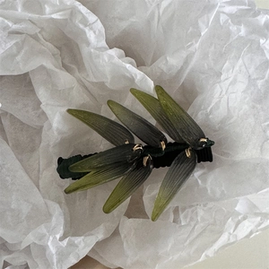 Vue détaillée de la pince à cheveux feuille dégradé olive avec base en tissu noir