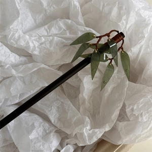 Vue détaillée de la pince à cheveux avec feuilles de bambou vertes et texture de jade