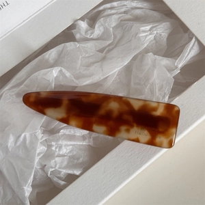 Detailed macro view of handmade acetate hair clip with classic tortoiseshell texture