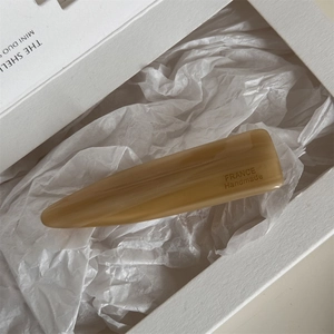 Detailed close-up of amber acetate hair clip with France Handmade engraving in a gift box