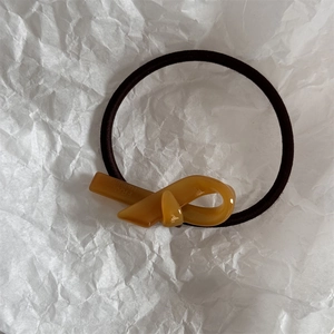 Dettaglio dell'elastico in acetato ambrato con incisione France Handmade su carta