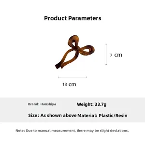 Détail d'une pince à cheveux ambre avec dimensions de 13cm et poids de 33,7g en gros plan