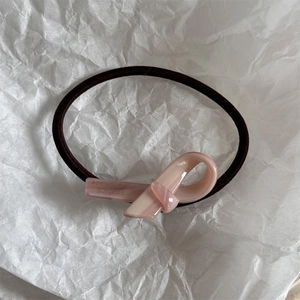 Dettaglio dell'elastico per capelli a nodo in acetato rosa con scritta France Handmade