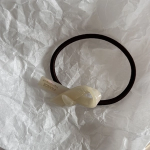 Dettaglio del nodo in acetato crema con scritta France Handmade su elastico per capelli