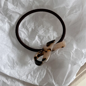 Dettaglio elastico per capelli in acetato tartarugato con incisione France Handmade