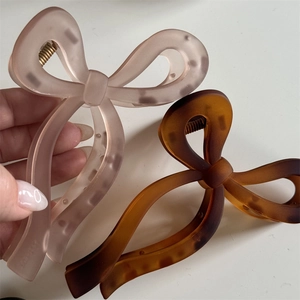 Détail de pinces à cheveux à nœud rose mat et écaille pour des coiffures élégantes