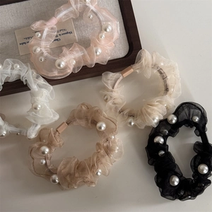 Detail of five organza hair scrunchies with white pearls in assorted pastel colors